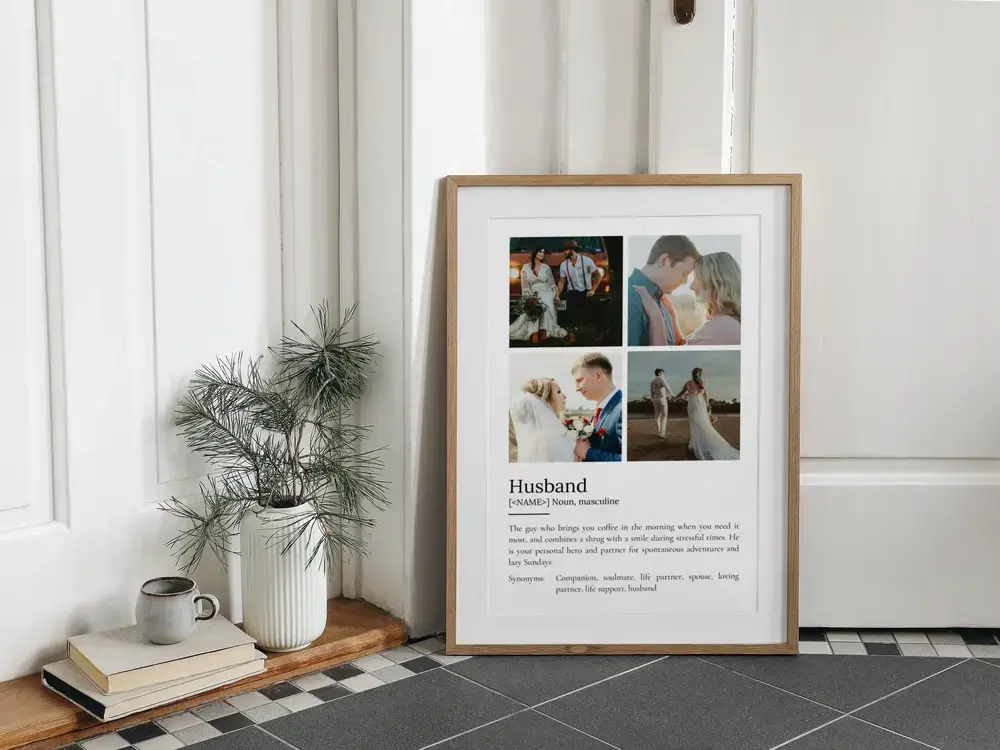 Husband definition poster with four photos in a wood frame, resting on a tiled floor beside books and a vase