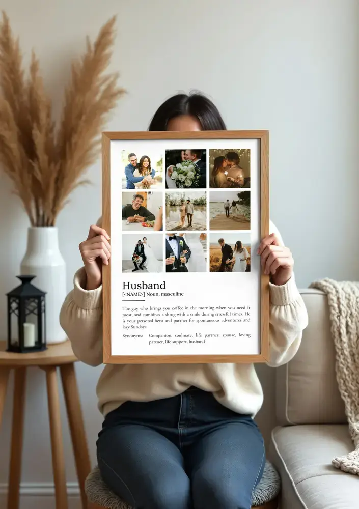 Wood-framed husband definition poster with a nine-photo wedding and couple collage, displayed in a cozy living room