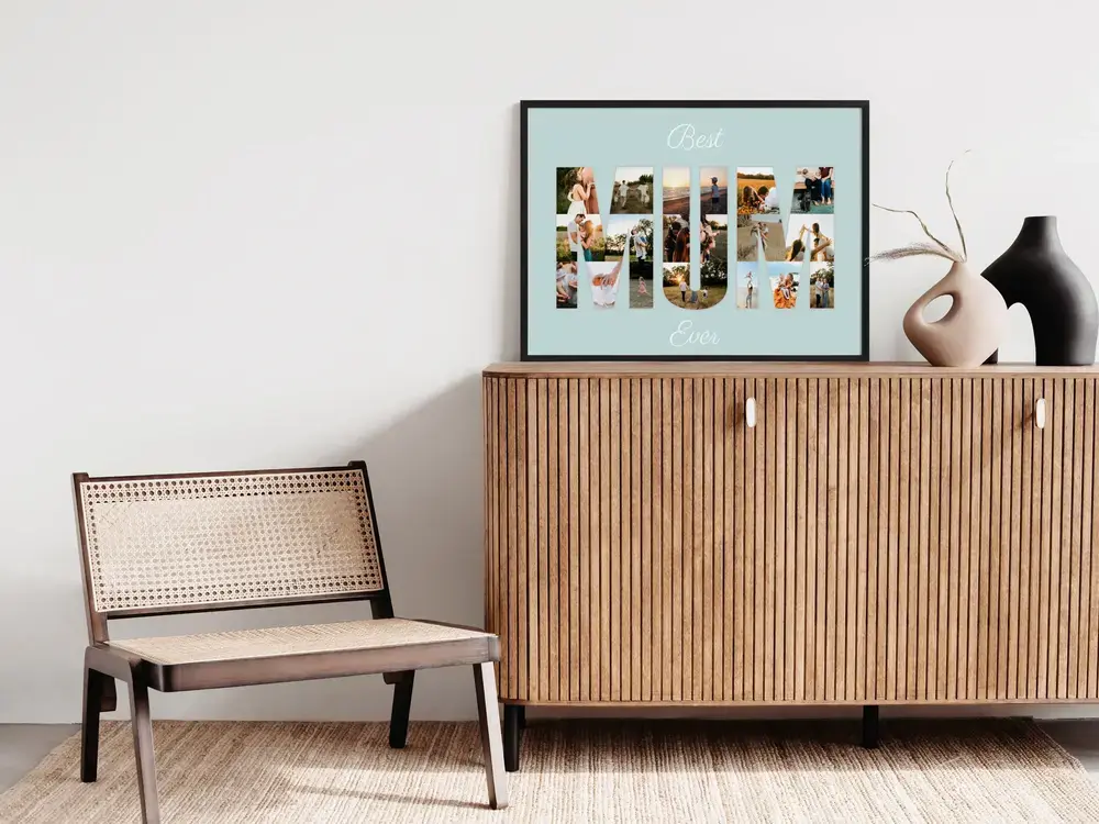 Black-framed photo letter collage on light blue, displayed on a wooden cabinet beside decorative vases