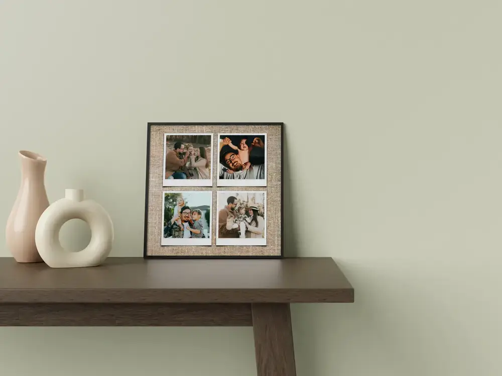 Framed family collage with four Polaroid-style photos on a linen-look background, on a console table beside white vases