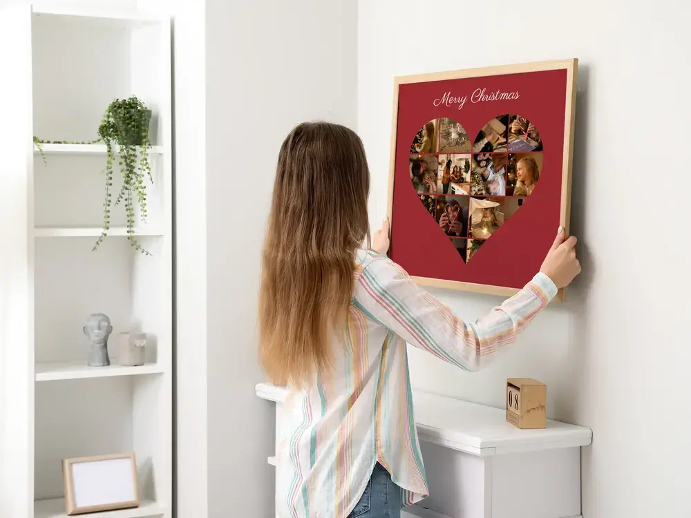 Wood-framed heart photo collage on deep red, displayed on a white wall as a personal Christmas gift